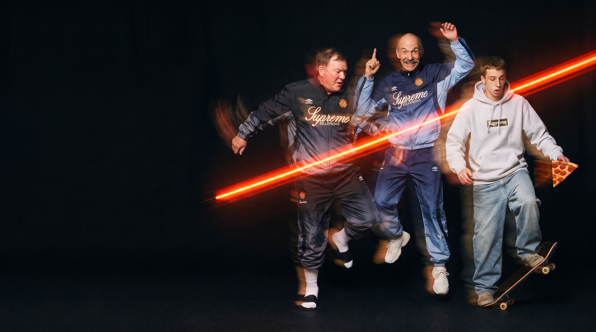 Three characters in Supreme x Umbro tracksuits and a Supreme box logo hoodie, mid-motion in a dark studio with an orange light streak